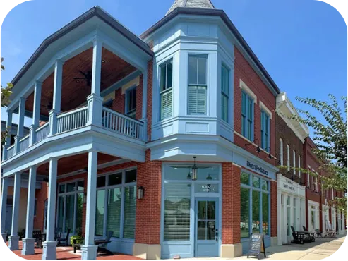 The Direct Pediatrics office at Norton Commons, a brick corner building with a blue two-story porch.